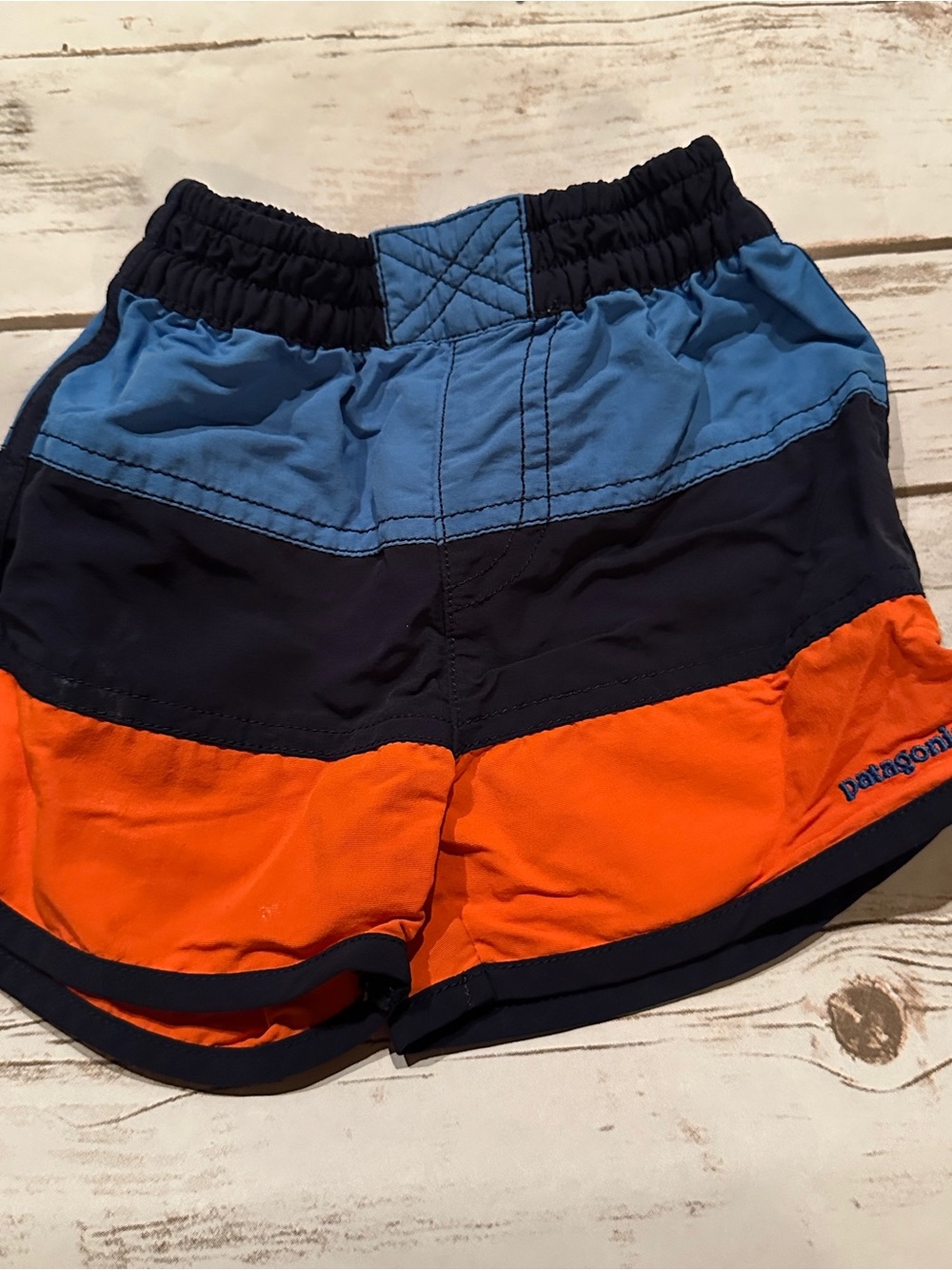 Patagonia shorts with blue, navy, and orange horizontal stripes